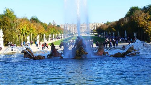a fountain in the water in front of a building at Les Versaillaises in Versailles