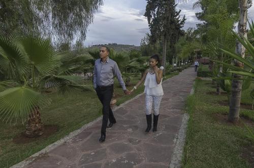 a man and woman walking down a path holding hands at Hotel Dar Eddaya in Khemisset