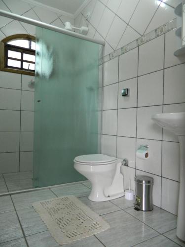 a bathroom with a toilet and a shower and a sink at Pousada Caruaru in Socorro