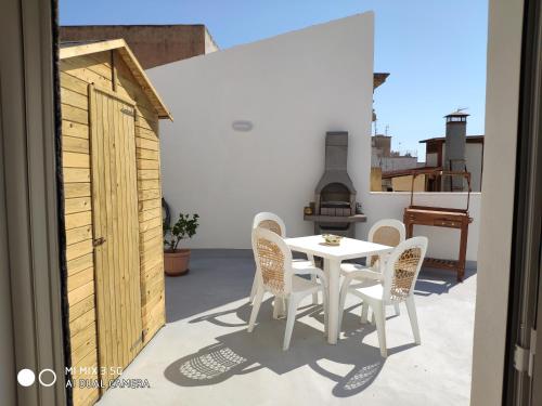 a white table and chairs on a balcony with a stove at Carlotta Home in Marsala