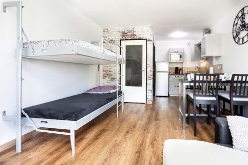 a bedroom with a bunk bed and a dining room at APPART PREMIUM DU LYS Balcon amenage Parking gratuit in Dammarie-lès-Lys