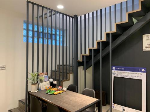 a dining room with a table and a staircase at Lukang Barn Inn in Lugang