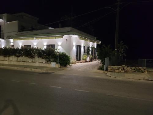 a white house with lights on the side of a street at Cala Paradiso in Monopoli