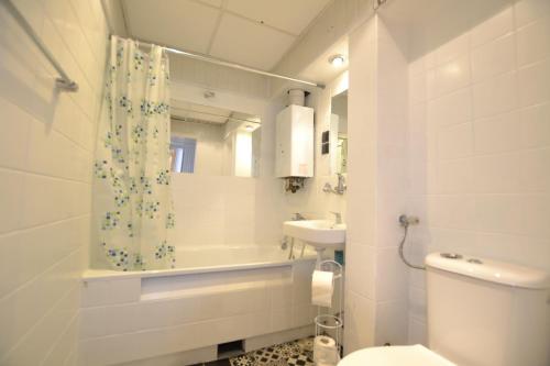 a white bathroom with a toilet and a sink at Apartament Błękitny-Centrum Racibórz in Racibórz