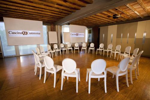 a room with a bunch of chairs and a projection screen at Agriturismo Cascina Caremma in Besate