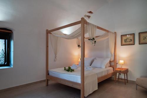 una camera con letto a baldacchino e lenzuola bianche di Marthas DeLight Rooms a Chania