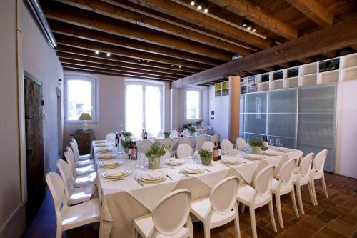 a large room with a long table and white chairs at Agriturismo Cascina Caremma in Besate