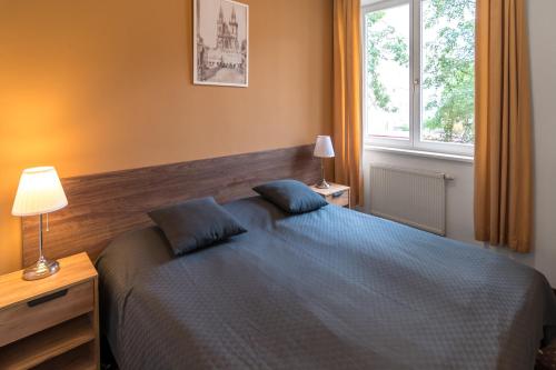 a bedroom with a blue bed and a window at Hotel Museum in Prague