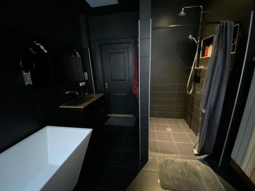 a black bathroom with a tub and a shower at Boutique Hostel Cesis-X in Cēsis