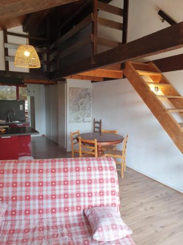 ein Wohnzimmer mit einem Tisch und einem Sofa sowie eine Küche in der Unterkunft Duplex 46m2 in Saint-Jean-Saint-Nicolas