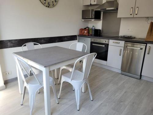 een witte tafel en stoelen in een keuken bij Ernella in Bastia