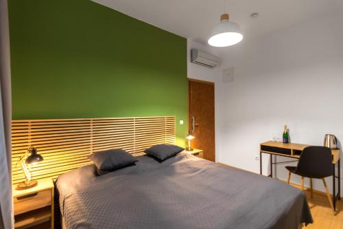 a bedroom with a green wall and a bed at Hotel Museum in Prague