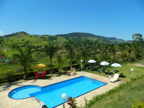 a swimming pool in a resort with mountains in the background at Pousada Caruaru in Socorro