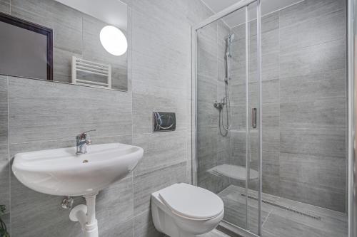 a bathroom with a toilet and a sink and a shower at Penzion Village Peace #29 by Goodnite cz - U Libušky in Brno
