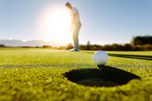 a man standing on a golf course with a golf ball at Casa Hibiscus Marbella in Marbella