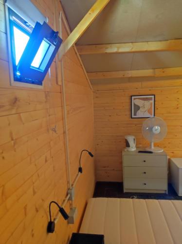a room with a bed and a lamp and a dresser at Parque de Campismo de Fão in Fão