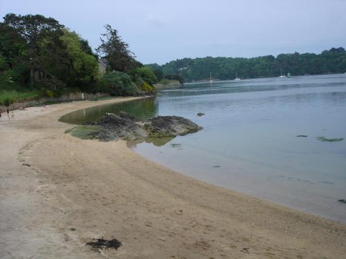 - une plage avec un rocher dans l'eau dans l'établissement Le gite de la plage, à Lézardrieux