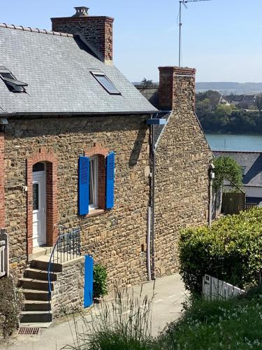 une maison en brique avec volets bleus dans l'établissement Le gite de la plage, à Lézardrieux