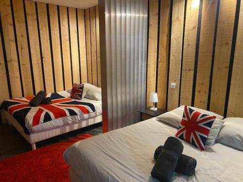 deux lits dans une chambre aux murs en bois dans l'établissement LOFT Tignes Val Claret, à Tignes