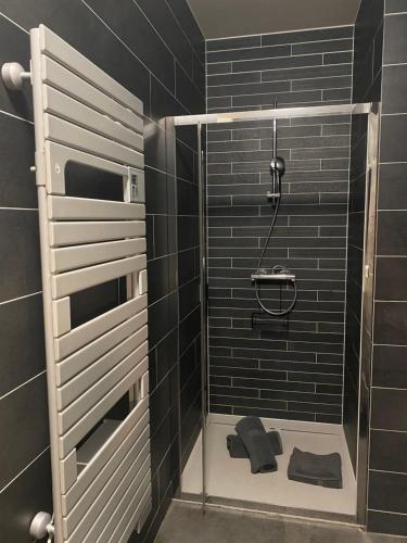 een badkamer met een douche met zwarte tegels bij LOFT Tignes Val Claret in Tignes