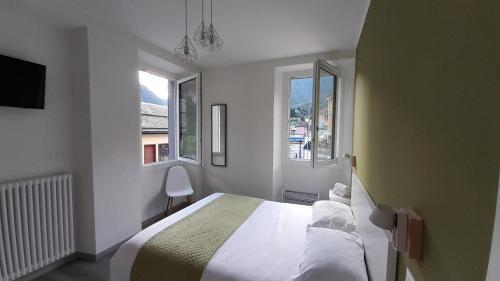 a white bedroom with a bed and two windows at CA' DEL VINO Rooms- Varzo in Varzo