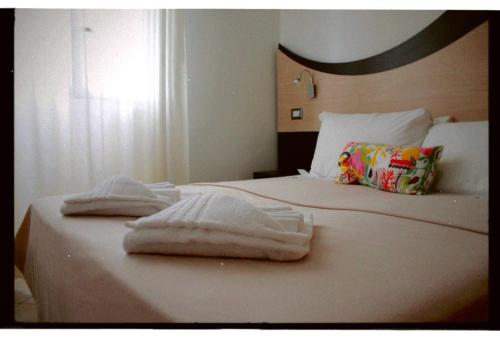 1 dormitorio con 1 cama con toallas en Tropicana Residence en Lido degli Estensi