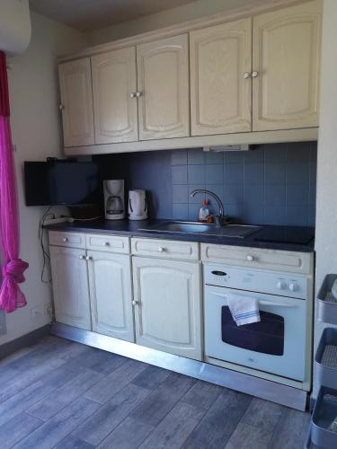 La cuisine est équipée de placards blancs et d'un four blanc. dans l'établissement La Grande-Motte : Appartement avec belle vue, à La Grande Motte