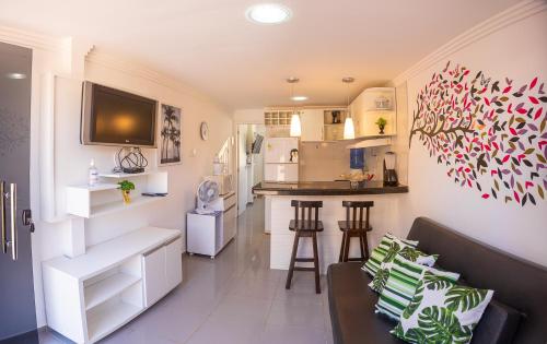 a living room with a couch and a kitchen at Apto na Praia de Guaibim in Guaibim