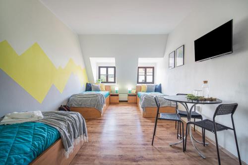 a room with a bed and a table with chairs at Penzion Village Peace #29 by Goodnite cz - U Libušky in Brno