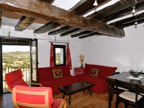 Cal Valeri في Montsonis: غرفة معيشة بأثاث احمر وطاولة