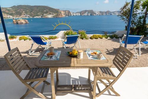 uma mesa e cadeiras de madeira com vista para o oceano em Maridea - Les Suites Du Soleil em Ponza