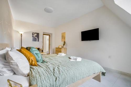 a bedroom with a bed with a television on the wall at Penzion Village Peace #29 by Goodnite cz - U Libušky in Brno