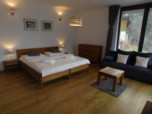 a bedroom with a bed and a couch at Penzion Eden in Pec pod Sněžkou