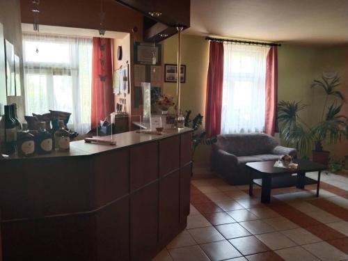 a kitchen with a counter and a living room with a couch at Hotel Jaro in Mělník
