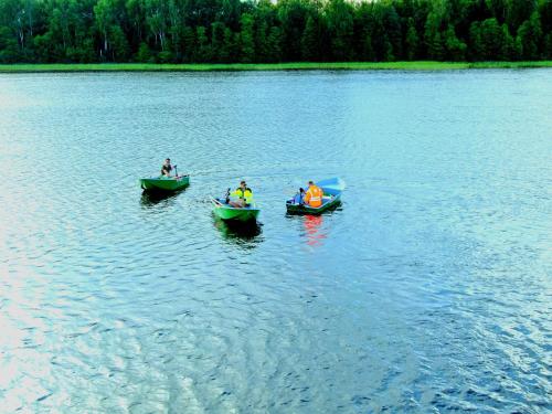 three people in boats on a large lake at Atpūtas vieta Ežezers in Andzeļi