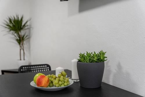 a plate of fruit on a table with a potted plant at Penzion Village Peace #29 by Goodnite cz - U Libušky in Brno