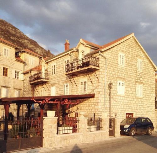 a building with a car parked in front of it at Lady of the Rocks apartments in Perast