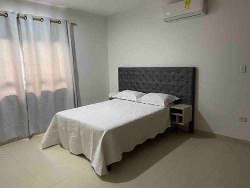 a bedroom with a large bed and a window at CIC APARTAMENTO CASTELLANA 3PISO PARQUEADERO GRATIS in Montería