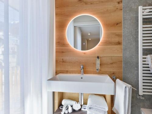 a bathroom with a white sink and a mirror at Hotel Zerbion in Torgnon