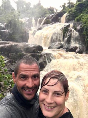 a man and a woman standing in front of a waterfall at Swim & Paint Art Retreat in Las Piedras