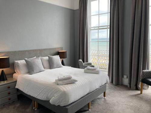 a bedroom with a bed and a large window at Norfolk Hotel in Weymouth