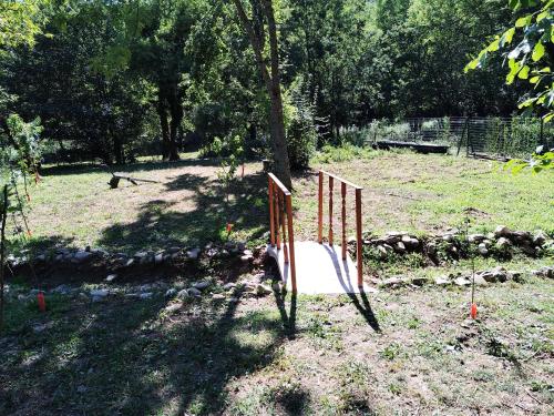 a gate in a field next to a tree at Green House in Rijeka