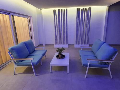 a living room with blue couches and a table at Sea Sky Lanzarote in Playa Blanca