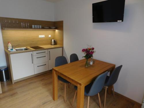 a kitchen and dining room table with chairs and a television at Penzion Eden in Pec pod Sněžkou