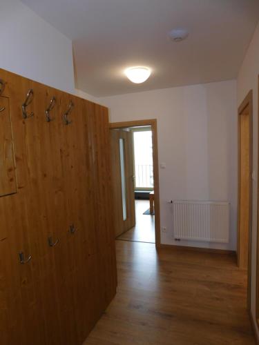 an empty room with wooden doors and a hallway at Penzion Eden in Pec pod Sněžkou