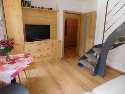 a living room with a tv and a table and a dining room at Penzion Eden in Pec pod Sněžkou