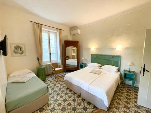 1 Schlafzimmer mit 2 Betten und einem Spiegel in der Unterkunft Hotel Villa Provencale in Cavalaire-sur-Mer