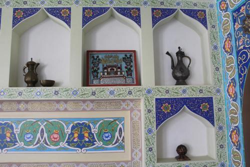 a wall with a shelf with colorful tiles on it at Mevlana Hotel in Samarkand