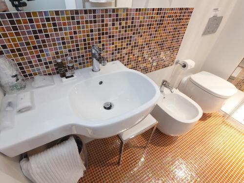 a white toilet sitting next to a sink in a bathroom at Hotel Annunziata in Ferrara
