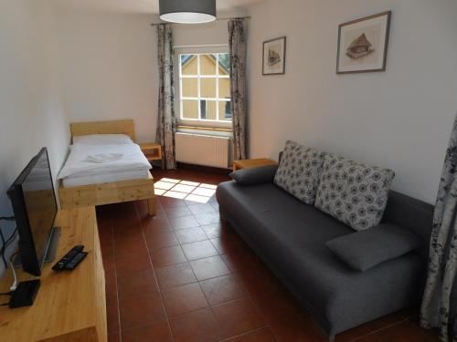 a living room with a couch and a bed at Penzion Eden in Pec pod Sněžkou